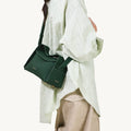 Green full-grain leather small drippy roof bag with microfiber lining and stainless steel hardware.