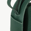 Green full-grain leather drippy roof bag with white stitching, showcasing texture and design.