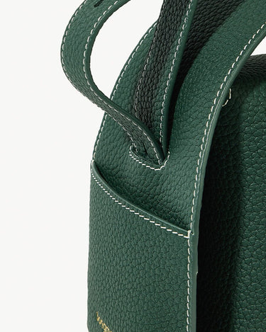 Green full-grain leather drippy roof bag with white stitching, showcasing texture and design.