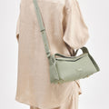 Small drippy roof bag in sage green full-grain leather with gold hardware and adjustable strap