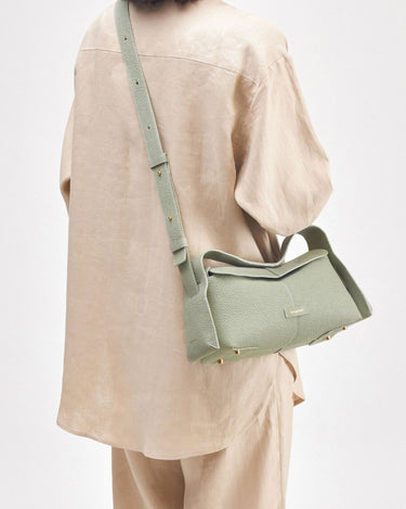 Small drippy roof bag in sage green full-grain leather with gold hardware and adjustable strap