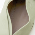 Light green full-grain leather small drippy roof bag interior with taupe lining and gold snap closure