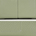 Light green full-grain leather handbag close-up with white stitching detail