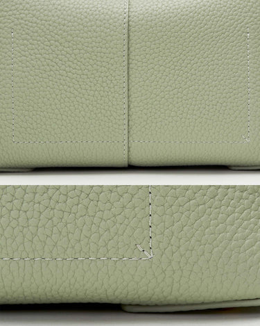 Light green full-grain leather handbag close-up with white stitching detail