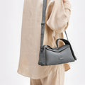 Small grey pebbled full-grain leather crossbody bag with adjustable strap