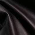 Close-up of flowing, textured ebony full-grain nappa leather.