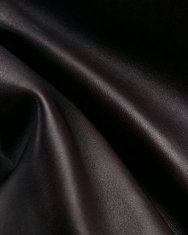 Close-up of flowing, textured ebony full-grain nappa leather.