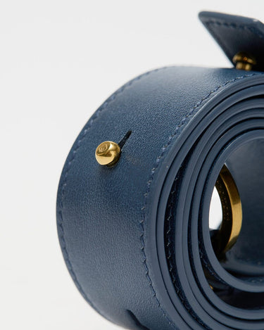 Navy small gather bag set in nappa leather with gold hardware, showcasing stitching and embossed logo detail.