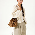 Ochre Suede Small Gather Bag Set worn by a woman in a cream knit cardigan and beige pants.