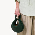 Small Luna Bag in Emerald green pebbled leather with gold hardware and twisted handle.