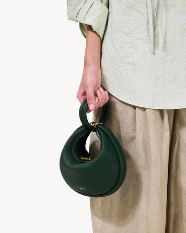 Small Luna Bag in Emerald green pebbled leather with gold hardware and twisted handle.