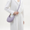 Small Luna Bag in lilac pebble leather with gold hardware, worn by a model.