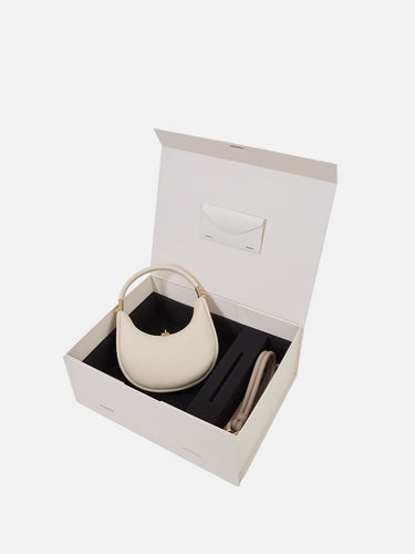 Small Luna bag in ivory full-grain leather with a pet leash in cream apricot, presented in a gift box.