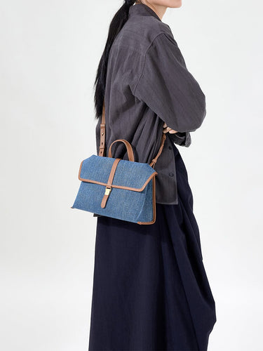 Small Shan Satchel Bag in denim with tan leather trim and gold buckle.