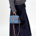 Small Shan Satchel Bag in blue denim with tan leather trim and strap.