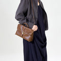 Small Shan Satchel Bag in Sandal color, crafted from vegetable-tanned leather with a golden buckle closure.