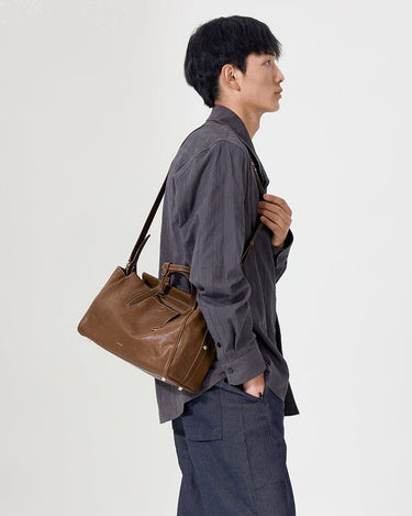 Small Yore Duffle Bag in Sandal brown leather, worn by a man over the shoulder.