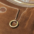 Close-up of Sandal Suede Small Yore Hobo Bag featuring a brass ring detail with embossed "Songmont" logo.