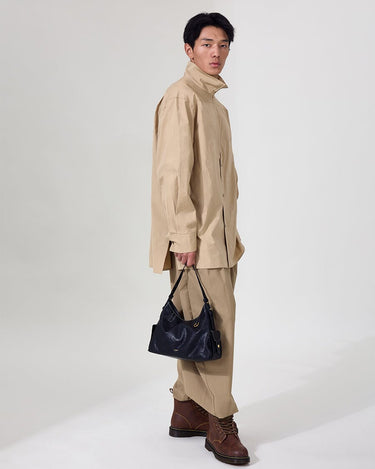 Small Yore Hobo Bag in Onyx carried by a model in beige attire.