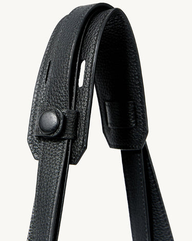 Small Yore Tote Bag in Onyx: Textured black leather strap with snap button detail.