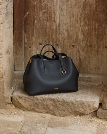 Songmont Small Yore Tote Bag in Onyx, crafted from pebbled full-grain leather with gold hardware.