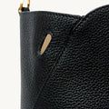 Black Yore tote bag detail with pebbled leather, gold D-ring, and subtle slit