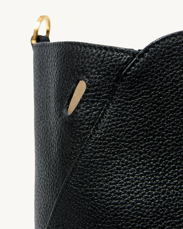 Black Yore tote bag detail with pebbled leather, gold D-ring, and subtle slit