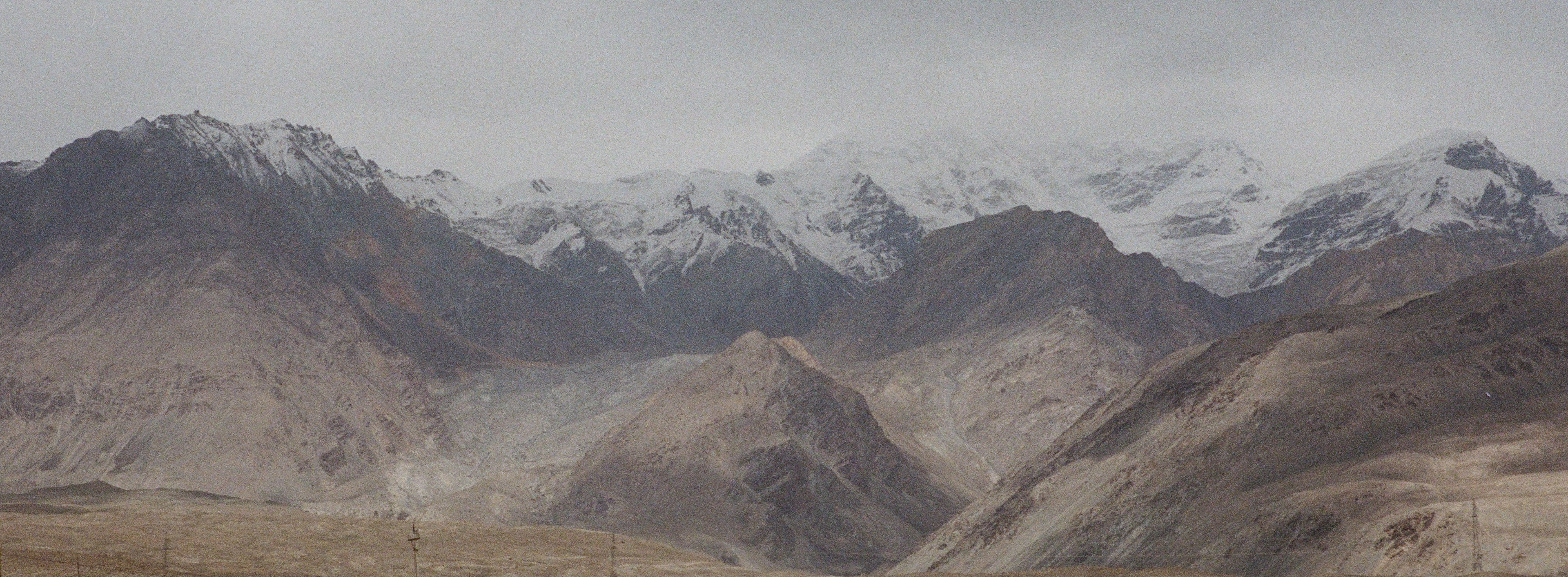 Snow-capped mountain range with barren landscape below