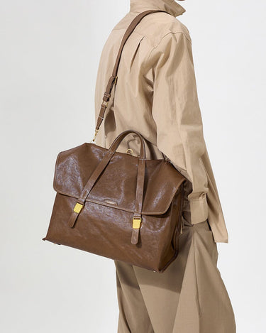 The Large Shan Briefcase in Sandal color, crafted from vegetable-tanned leather with brass hardware.