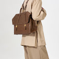 The Large Shan Briefcase in Sandal brown vegetable-tanned leather, featuring adjustable straps and brass hardware.
