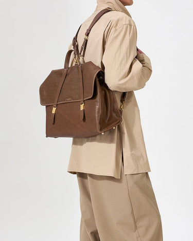 The Large Shan Briefcase in Sandal brown vegetable-tanned leather, featuring adjustable straps and brass hardware.