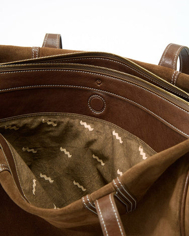 Medium Yore Duffle Bag in Sandal Suede, showcasing interior with patterned lining, zippers, and suede leather details.