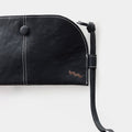 Black vegetable-tanned leather Yore Glasses Case with white stitching, button, and lanyard.