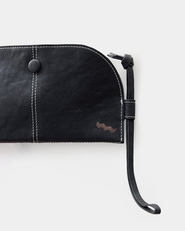 Black vegetable-tanned leather Yore Glasses Case with white stitching, button, and lanyard.