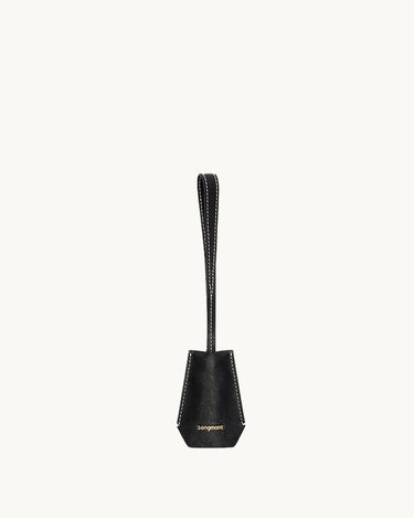 Black Yore keychain tag made of vegetable-tanned leather with gold "songmont" logo and white stitching.
