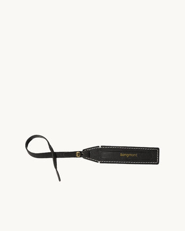 Yore Luggage Tag: black vegetable-tanned leather with white stitching and gold buckle. Features 'Songmont' embossed.