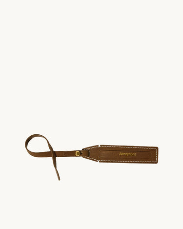 The Yore Luggage Tag in vegetable-tanned leather with "Songmont" embossed.