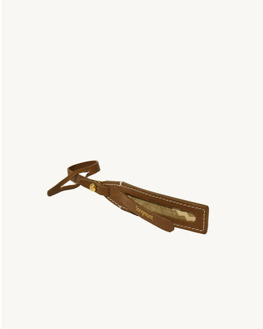 Brown vegetable-tanned leather luggage tag with white stitching and gold "Songmont" embossed logo