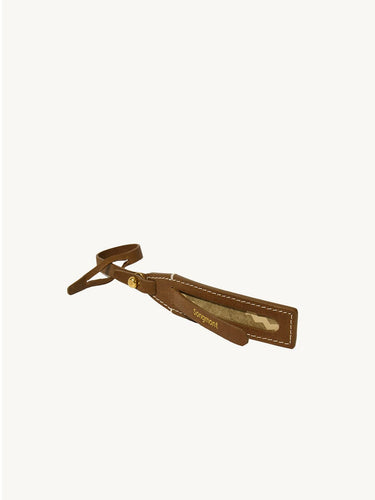 Brown vegetable-tanned leather luggage tag with white stitching and gold "Songmont" embossed logo
