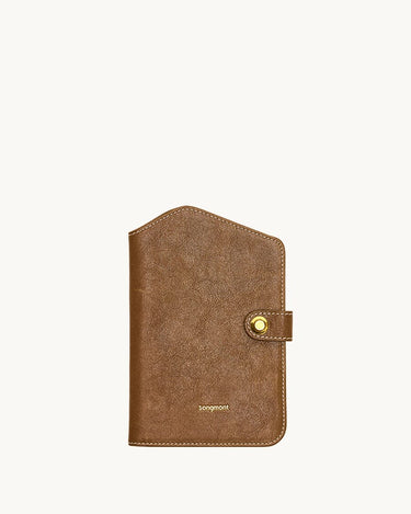 Brown Yore Passport Case in Sandal color by Songmont, featuring vegetable-tanned leather and a brass snap closure.