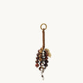 Caramel Wish Seeds Charm with assorted natural beads and a leather-wrapped loop.