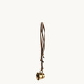 Vintage-inspired brass cup charm with adjustable leather cord, ideal for bags and necklaces.
