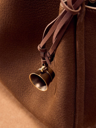 Sandal colored Worry-Free Cup Charm with aged metal finish and leather tie