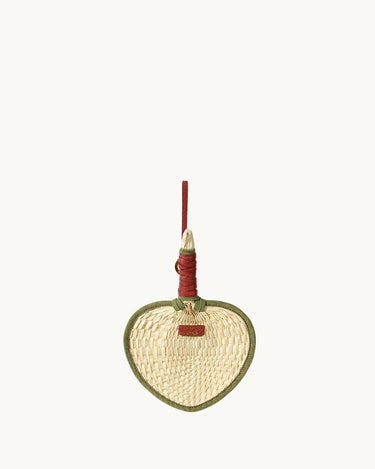 Woven fan charm with green trim and red handle, crafted from palm fronds