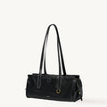 Black Yore Baguette Bag, vegetable-tanned leather, white stitching, gold hardware. Modern and structured design.