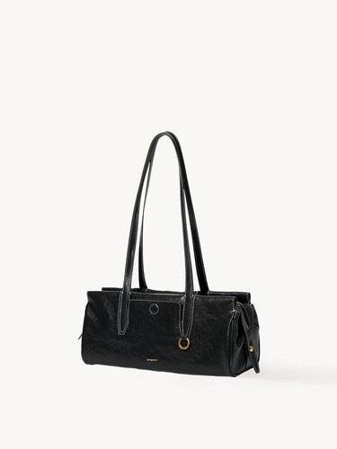 Black Yore Baguette Bag, vegetable-tanned leather, white stitching, gold hardware. Modern and structured design.