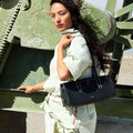 Woman with black Yore Baguette Bag in onyx, featuring vegetable-tanned leather and stainless steel hardware.