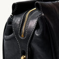 Black Yore Baguette Bag with gold zipper and white stitching, vegetable-tanned leather