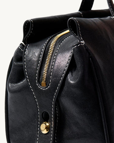 Black Yore Baguette Bag with gold zipper and white stitching, vegetable-tanned leather