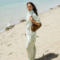 Yore Baguette Bag in Sandal color carried by a woman on a beach